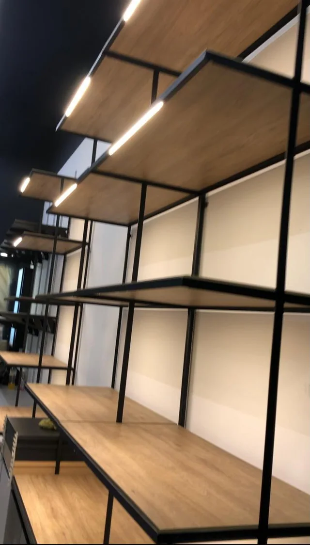 Estructura de exhibición mural con repisas negras para retail